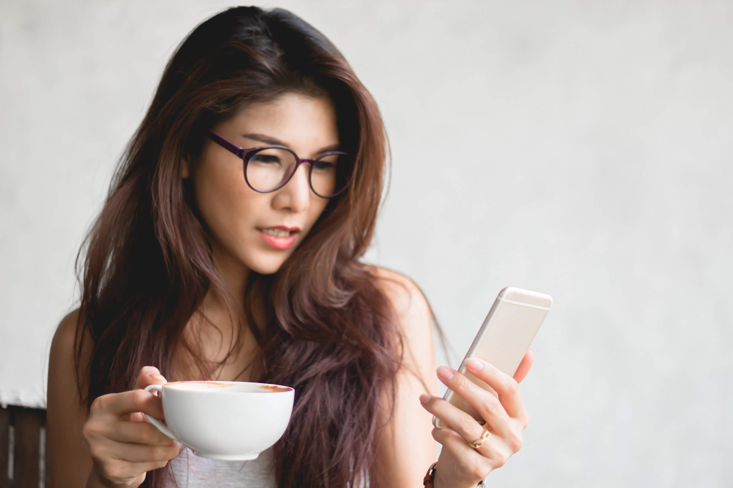 Woman with coffee and cell phone